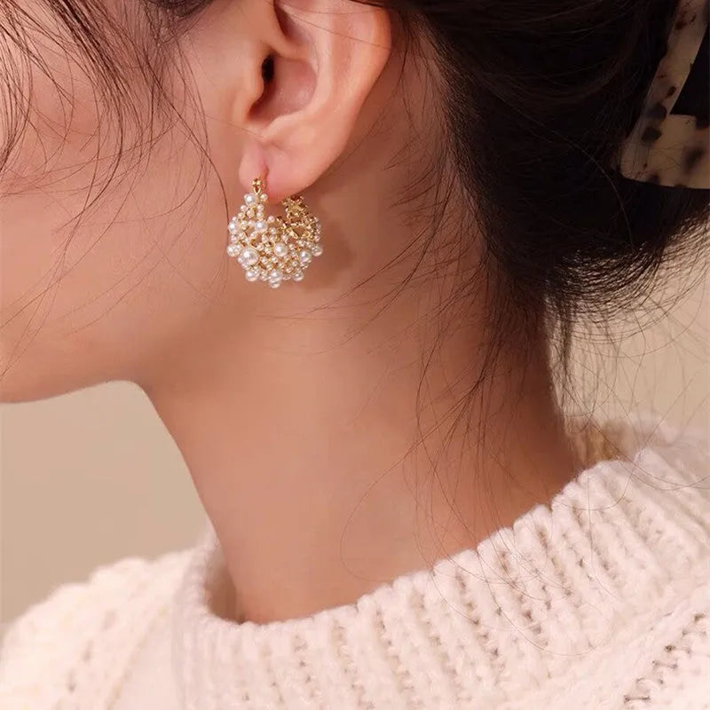 Gold-coloured copper flower basket earrings with small rice-shaped beads and pearl inlay detailing.