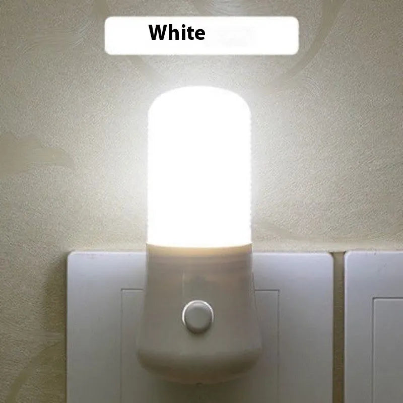 Minimalist white plug-in bedside night light with compact dimensions installed in wall socket
