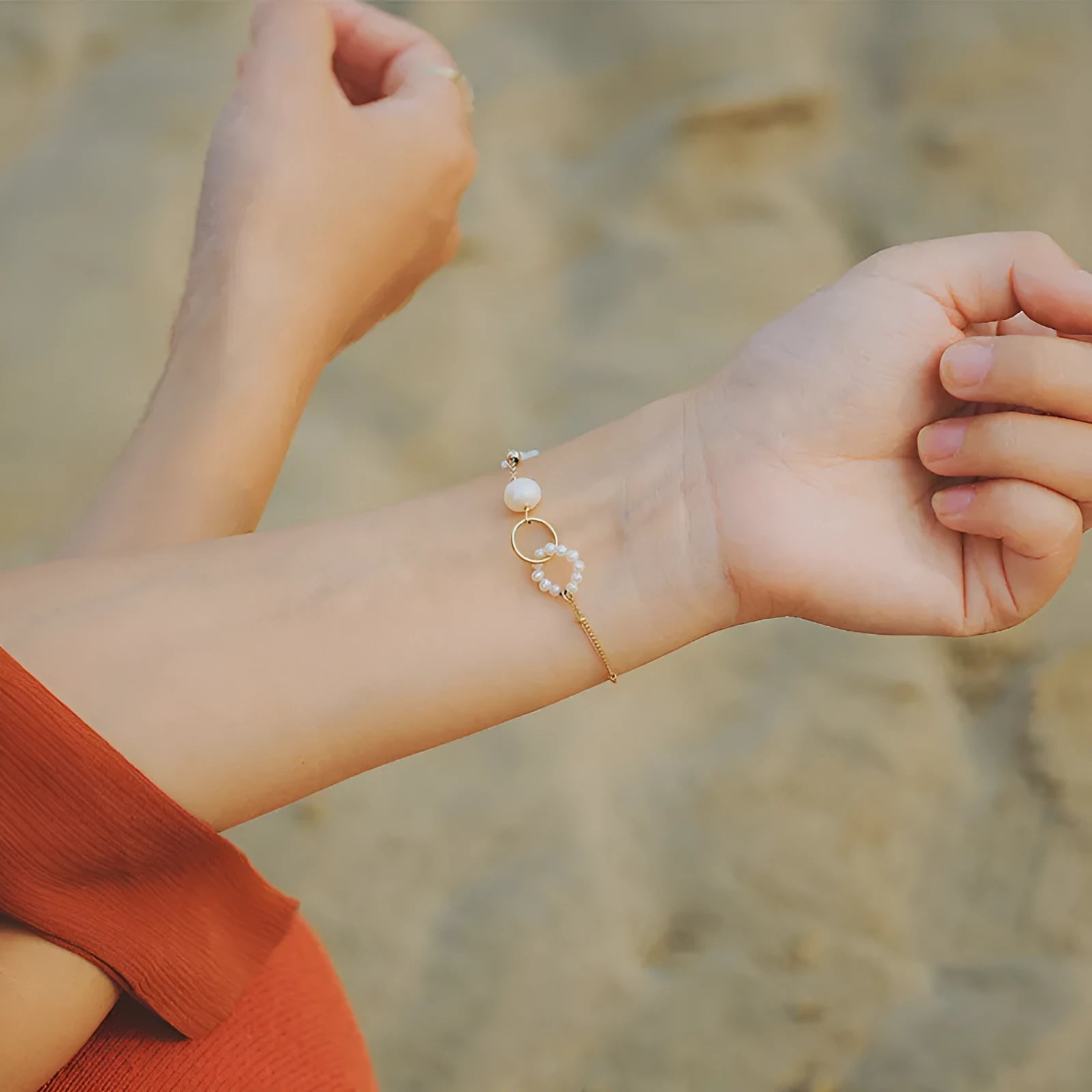 Close-up of a women's natural pearl bracelet with 14k gold-plated metal detailing.