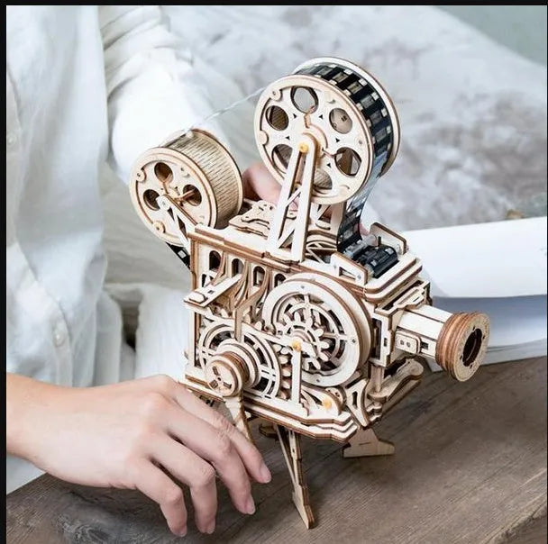Wooden three-dimensional puzzle film projector with hand crank and gear wheel assembly