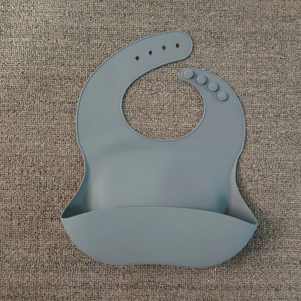 Soft waterproof silicone baby bib with food catcher in pink, with adjustable neck closure