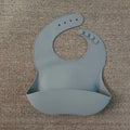 Soft waterproof silicone baby bib with food catcher in pink, with adjustable neck closure