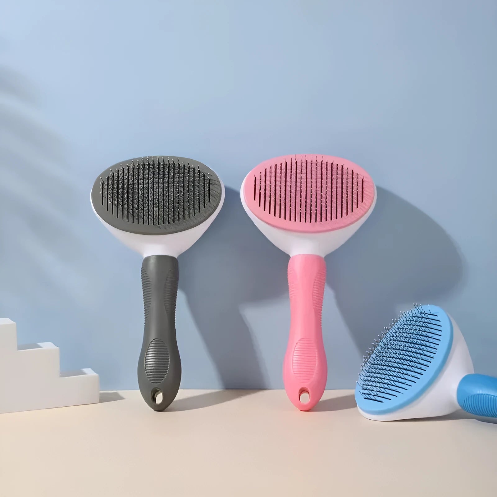 Pet hair removal comb with stainless steel teeth and light blue ABS handle on white background
