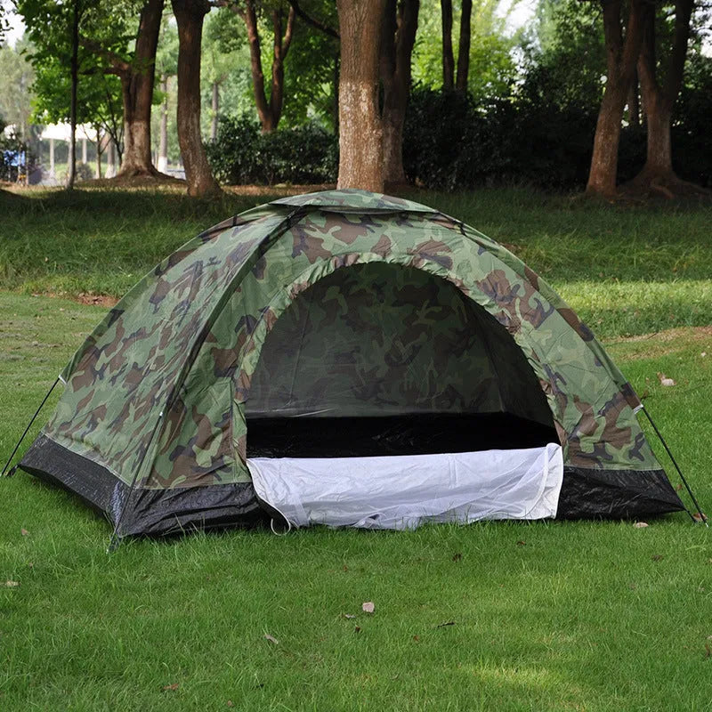 Green camouflage two-person camping tent with triangular skylight and fibre glass poles pitched outdoors.