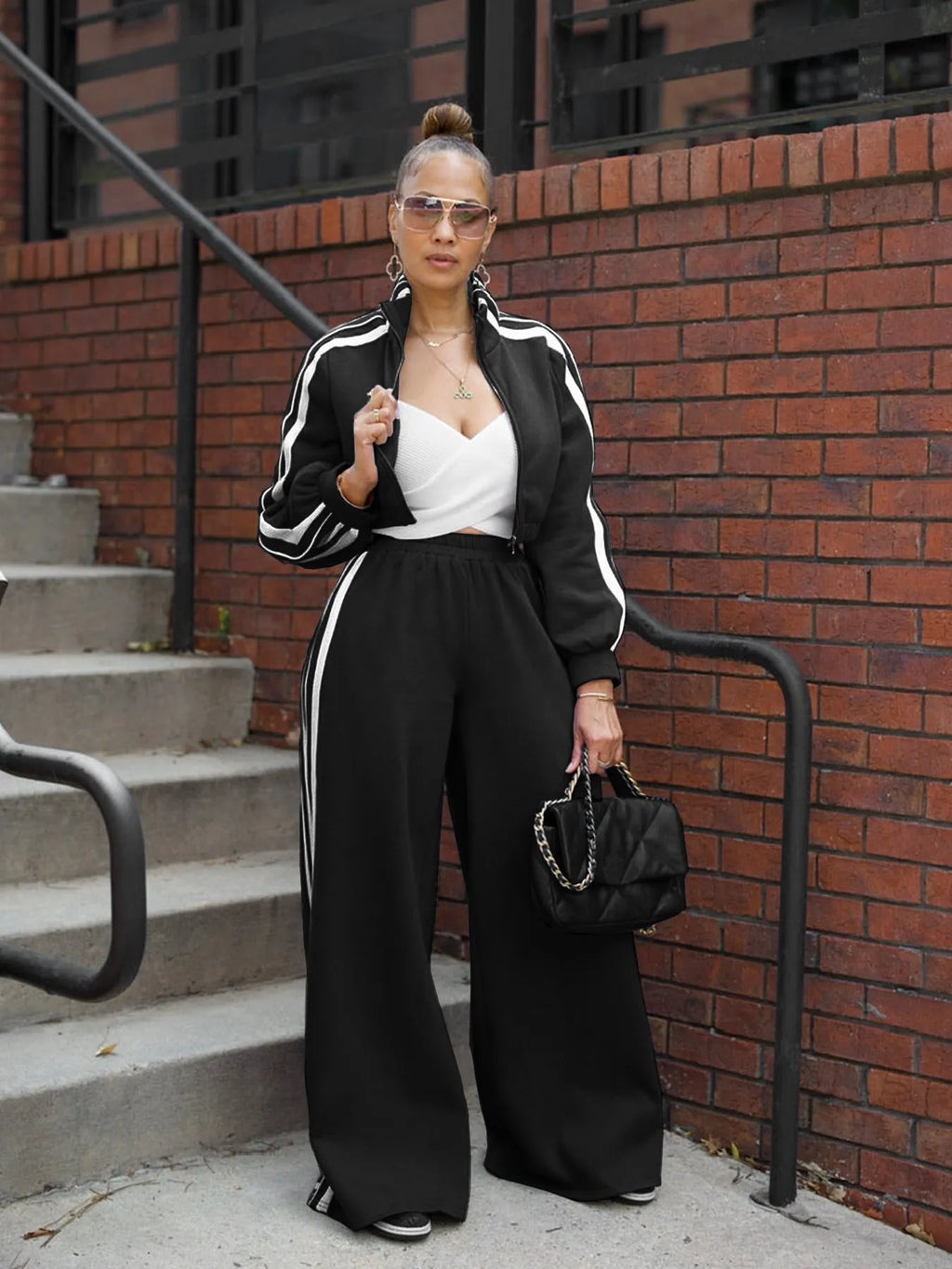 Grey striped two-piece sweater set with a zippered top and matching trousers on a model.
