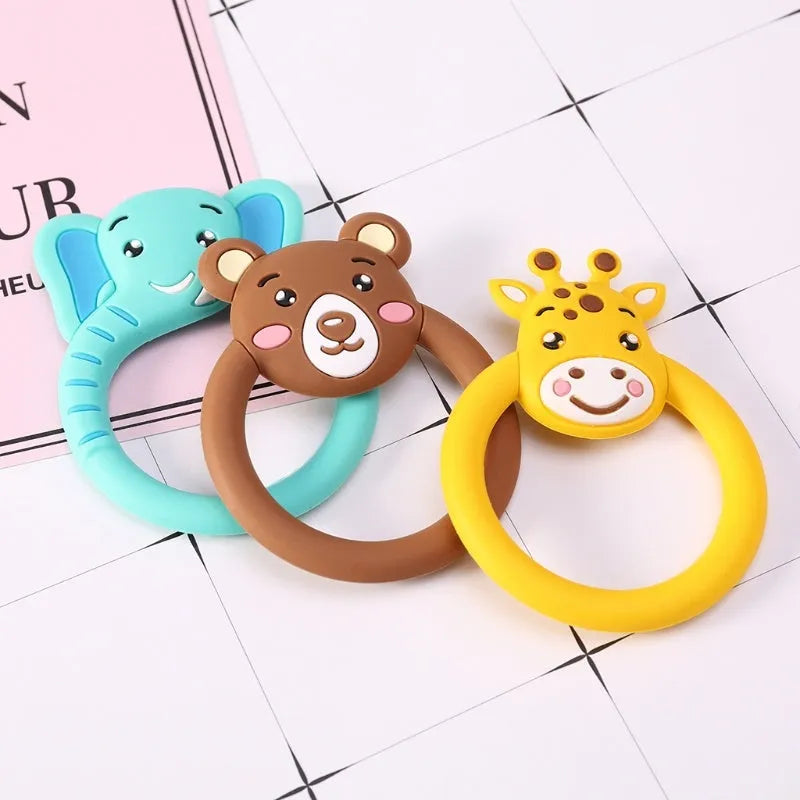Three silicone baby molar teethers in brown, blue, and yellow on a light background