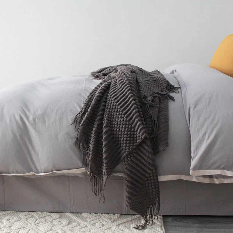 Small grey polyester nap blanket folded, showing its size and texture.