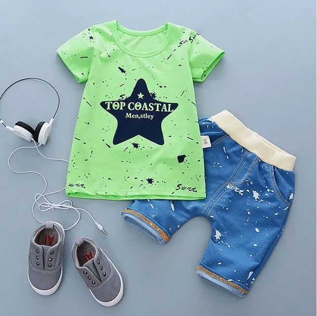 Baby boy wearing a blue crocodile print cotton t-shirt and matching blue shorts summer outfit set.