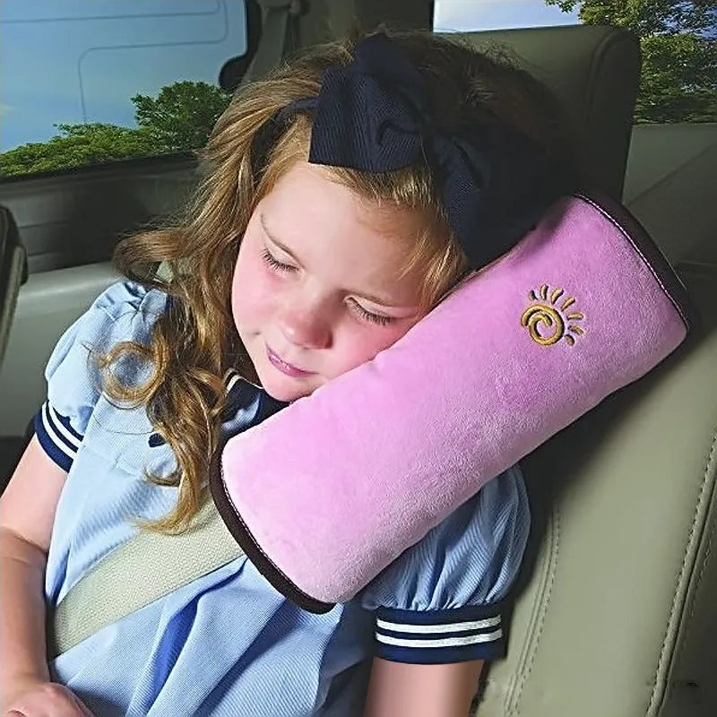 Children car pillow in grey micro-suede fabric attached to a car seat belt shoulder strap