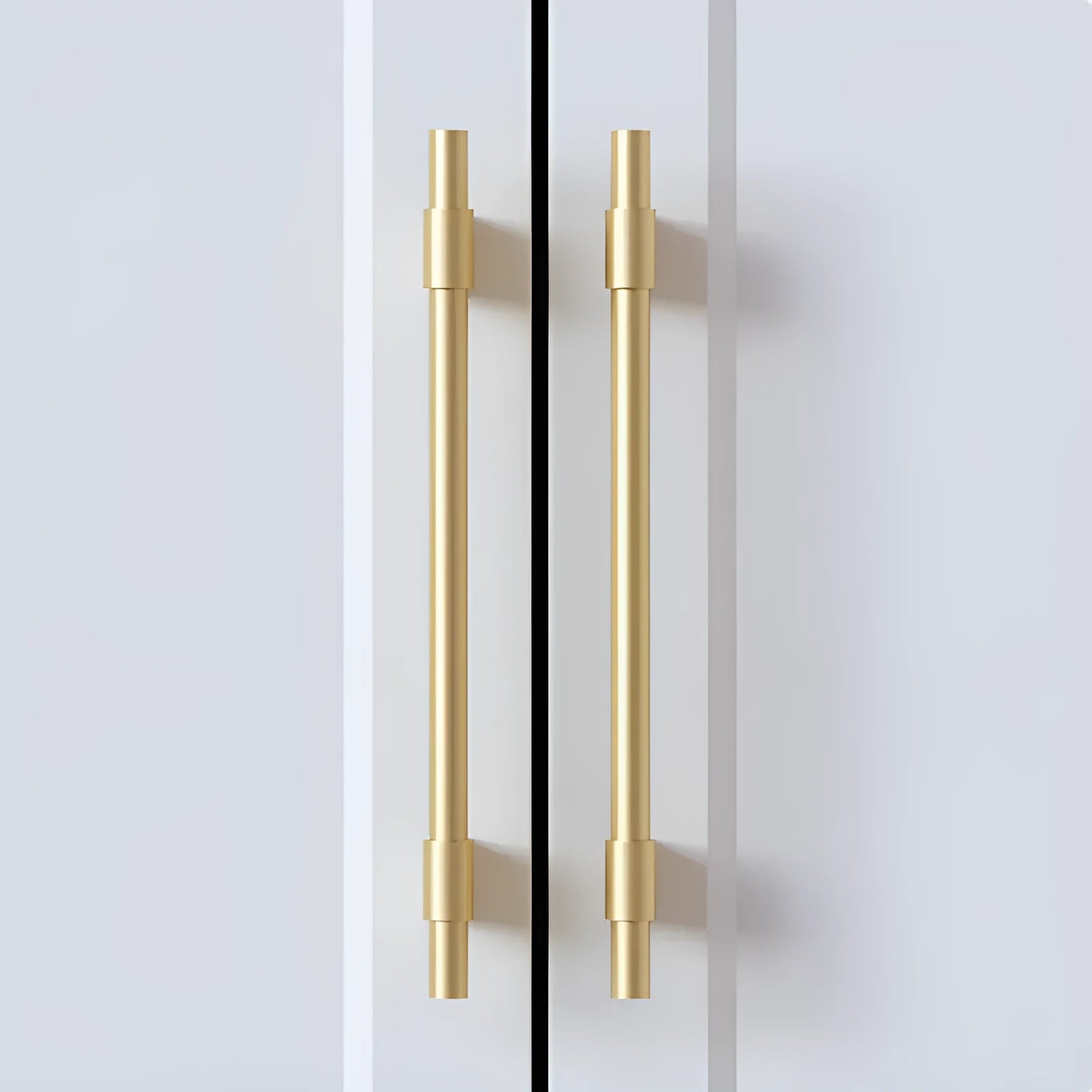 Gold brass single hole drawer handle on white cabinet door – minimalist metal pull