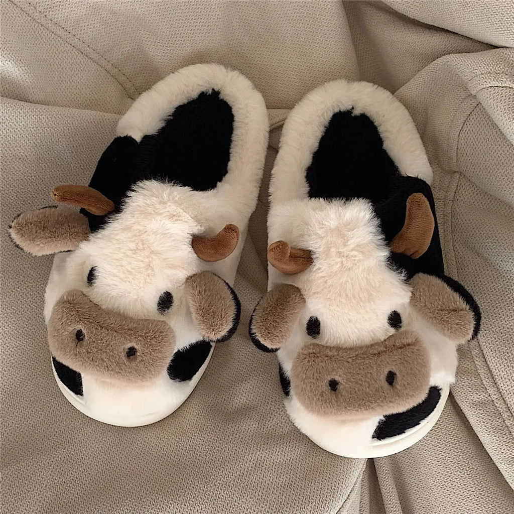 White women's cow pattern slippers made of soft faux fur with textured anti-slip soles.