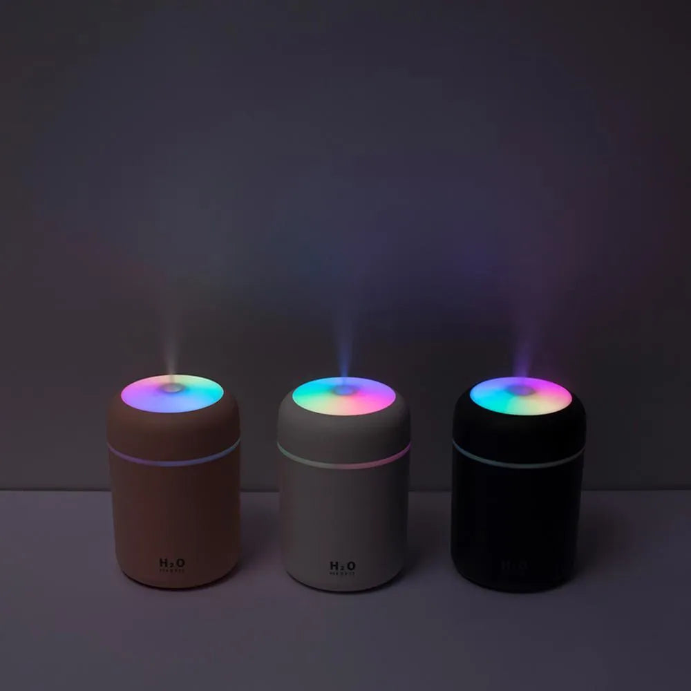 Pink, white, or navy blue USB mini humidifier with colourful lights on a desk