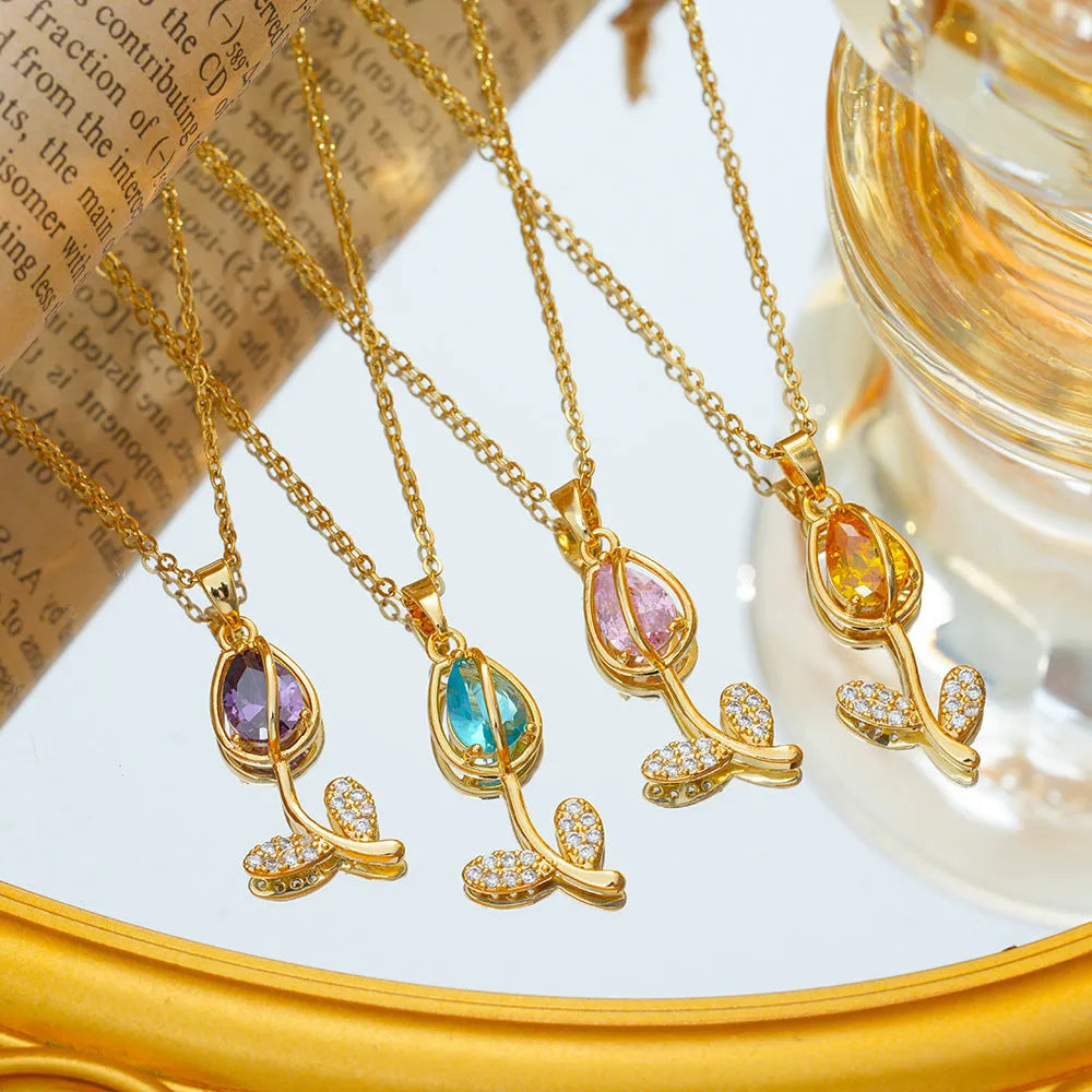 Gold-toned titanium steel necklace with a floral tulip pendant on an O-ring chain.