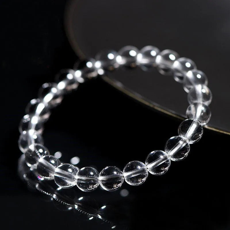 Natural old mine white crystal bracelet with round geometric beads on a wrist.