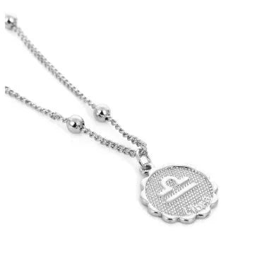 Gold plated metal zodiac constellation pendant necklace with bead chain on white background