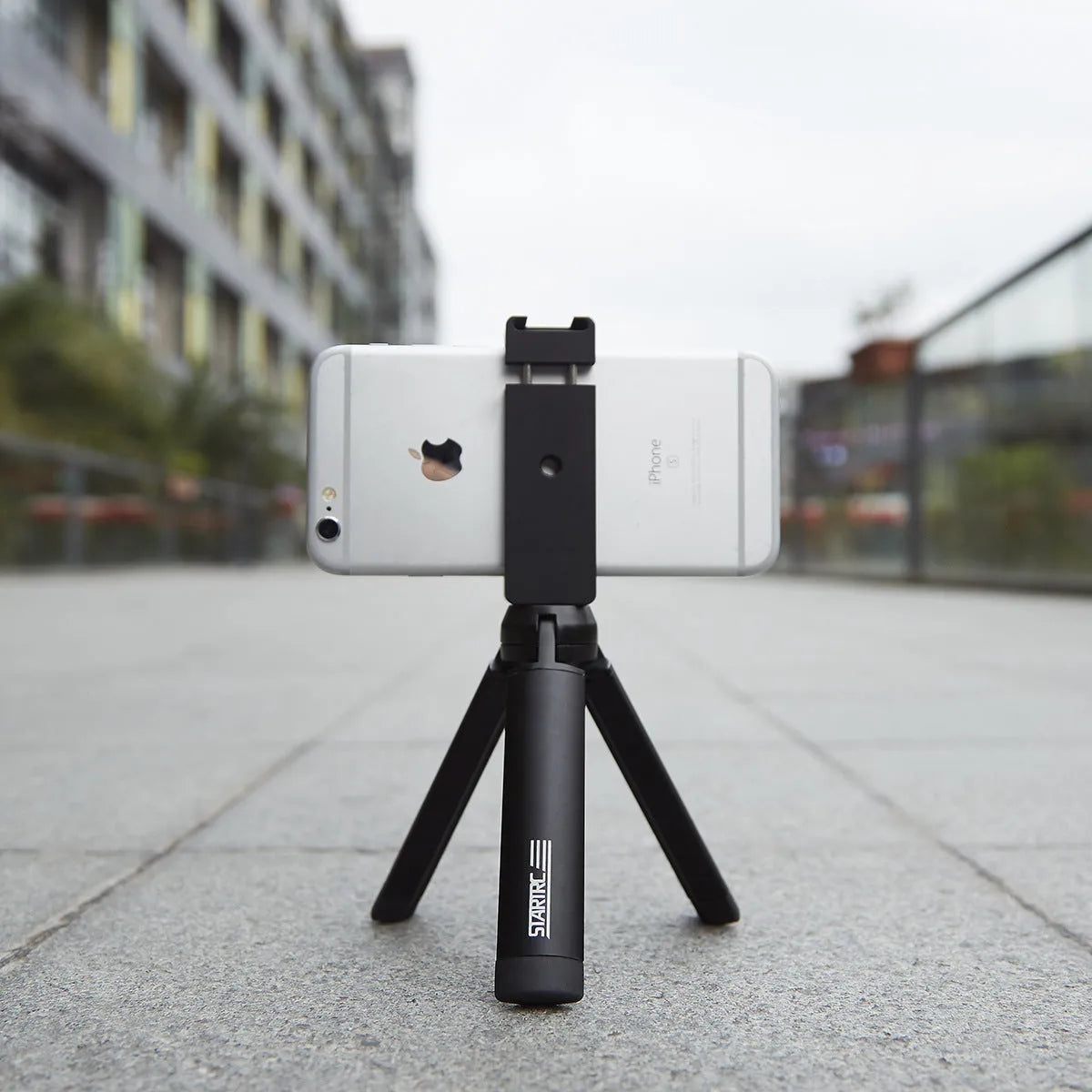 Silver aluminium alloy clip bracket for mounting an Apple iPhone onto a table-top tripod.