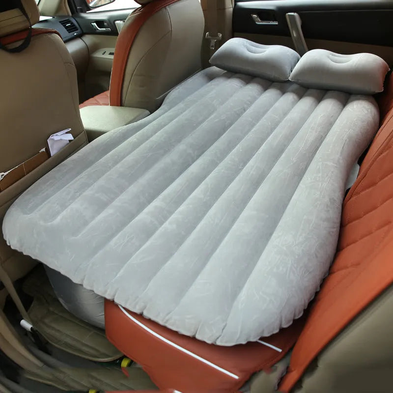 Black inflatable car bed with flocked material laid out in a five-seater vehicle boot.
