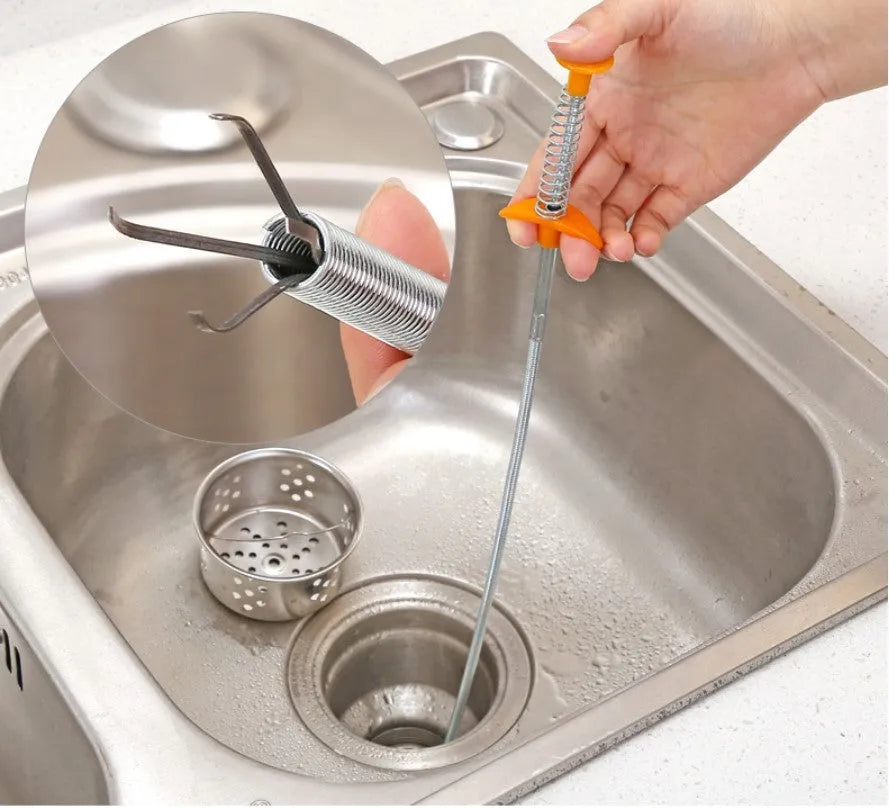 Black sewer dredge spring drain unclogging tool with PP handle next to a kitchen sink