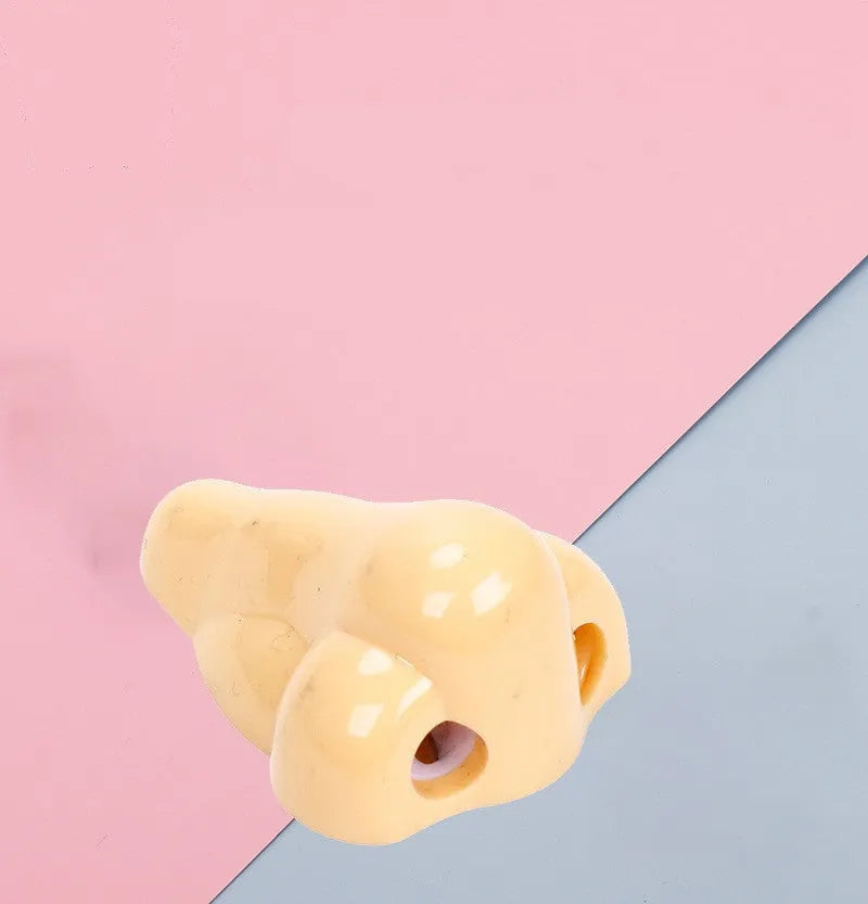 Flesh colour plastic manual pencil sharpener with big nostril hole on geometric body.