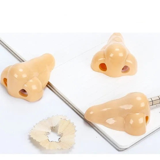Flesh colour plastic manual pencil sharpener with big nostril hole on geometric body.