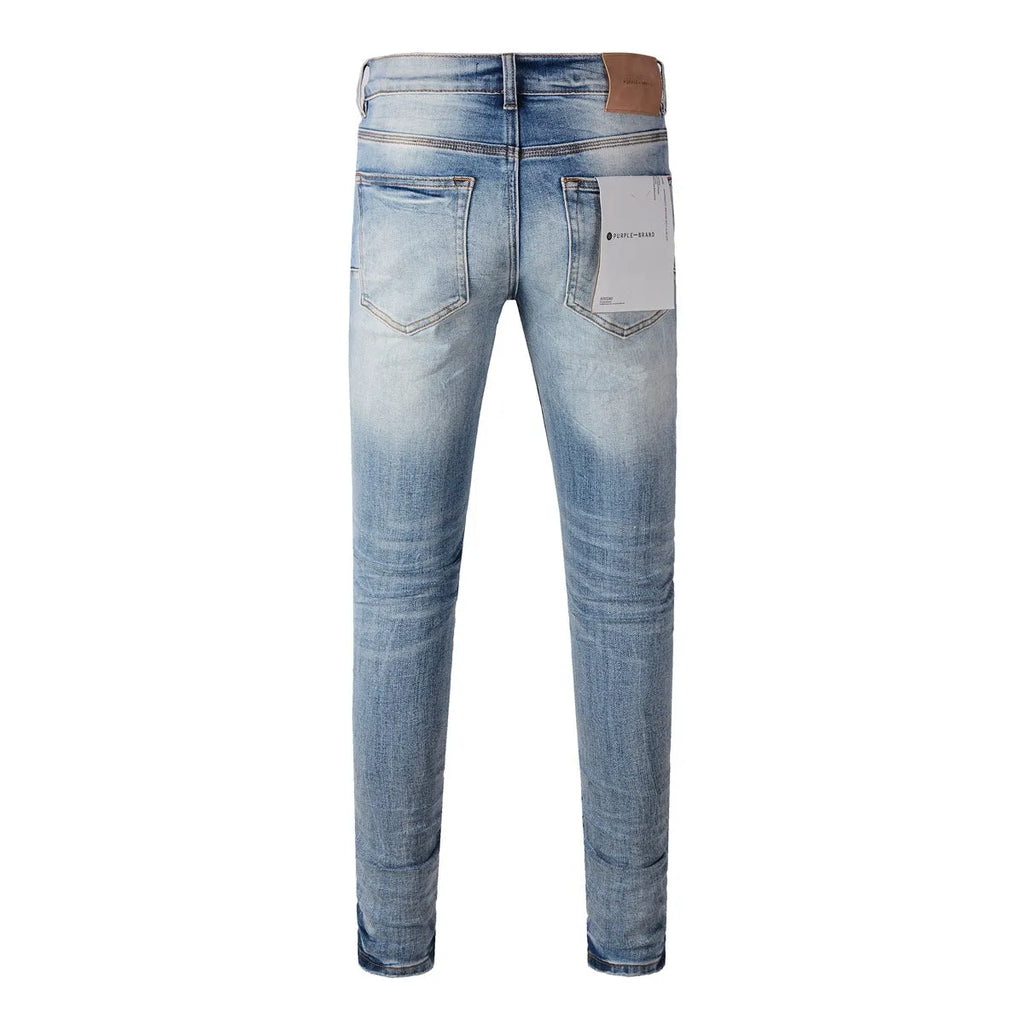 Men's blue denim pencil leg jeans with low waist and zipper fly on a person standing