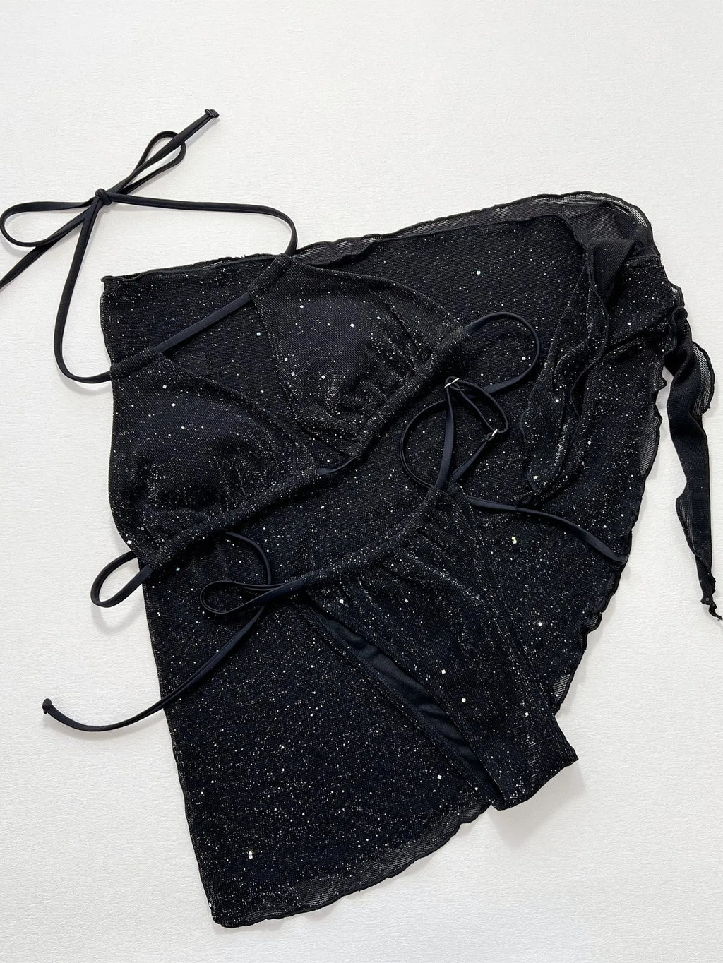 Black three-piece bikini swimsuit set with top and shorts on a plain background.