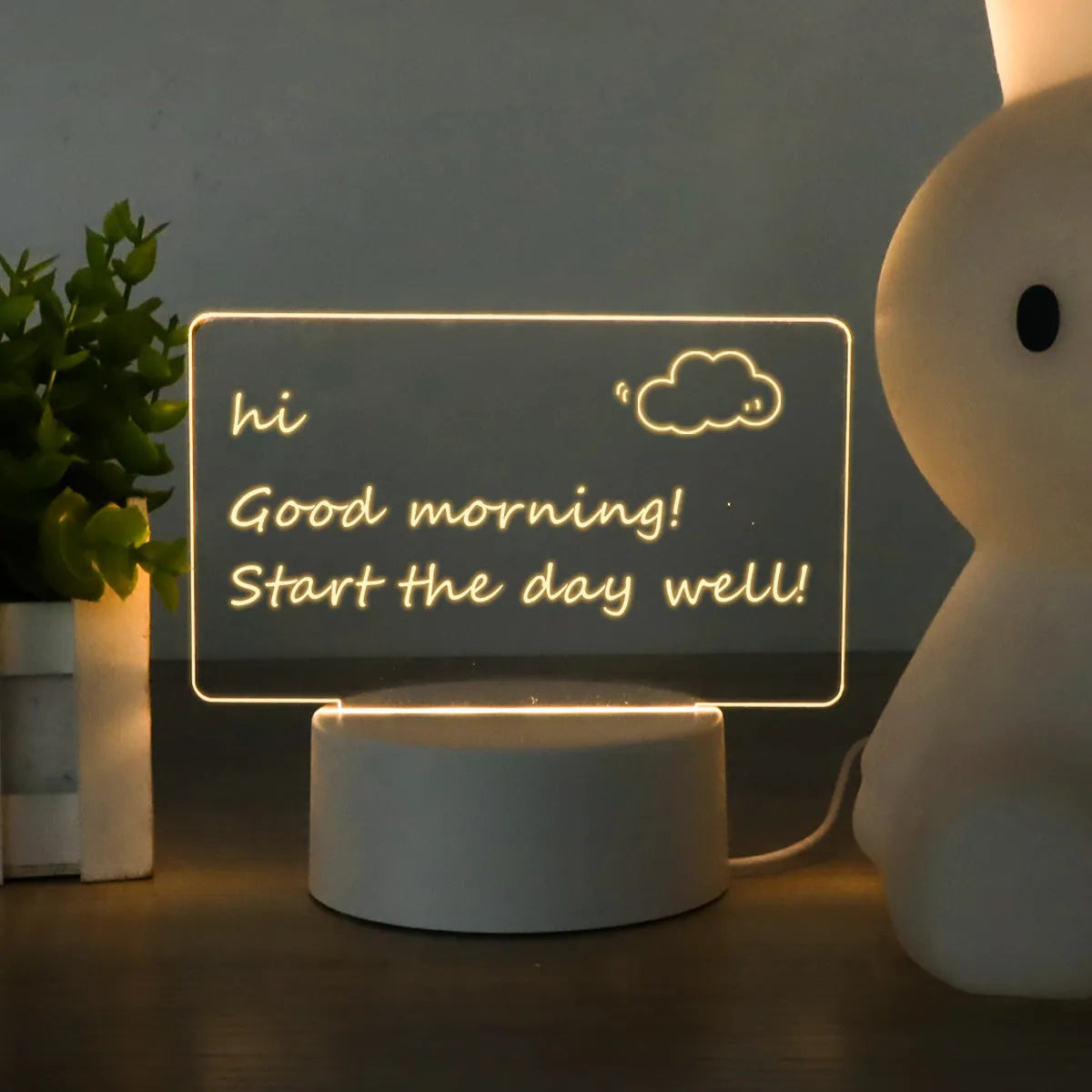 Heart-shaped LED light note board with USB warm yellow glow, base, and pen on a desk