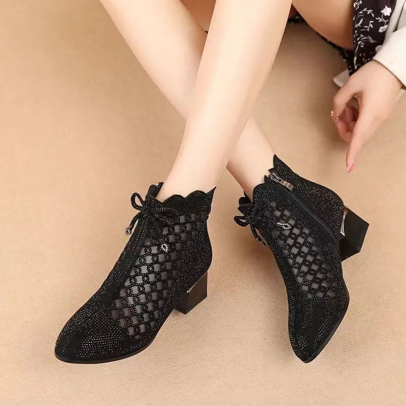Women's black cutout mesh ankle boots with mid heel and rhinestone trim, side zipper closure