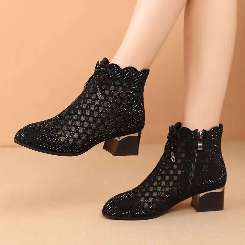 Women's black cutout mesh ankle boots with mid heel and rhinestone trim, side zipper closure
