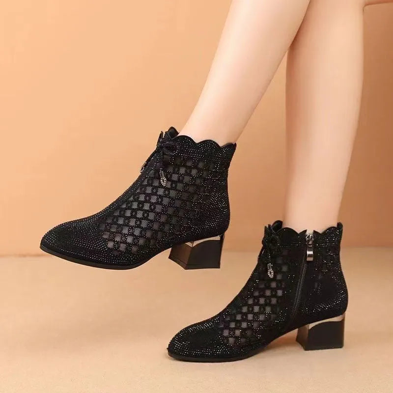 Women's black cutout mesh ankle boots with mid heel and rhinestone trim, side zipper closure