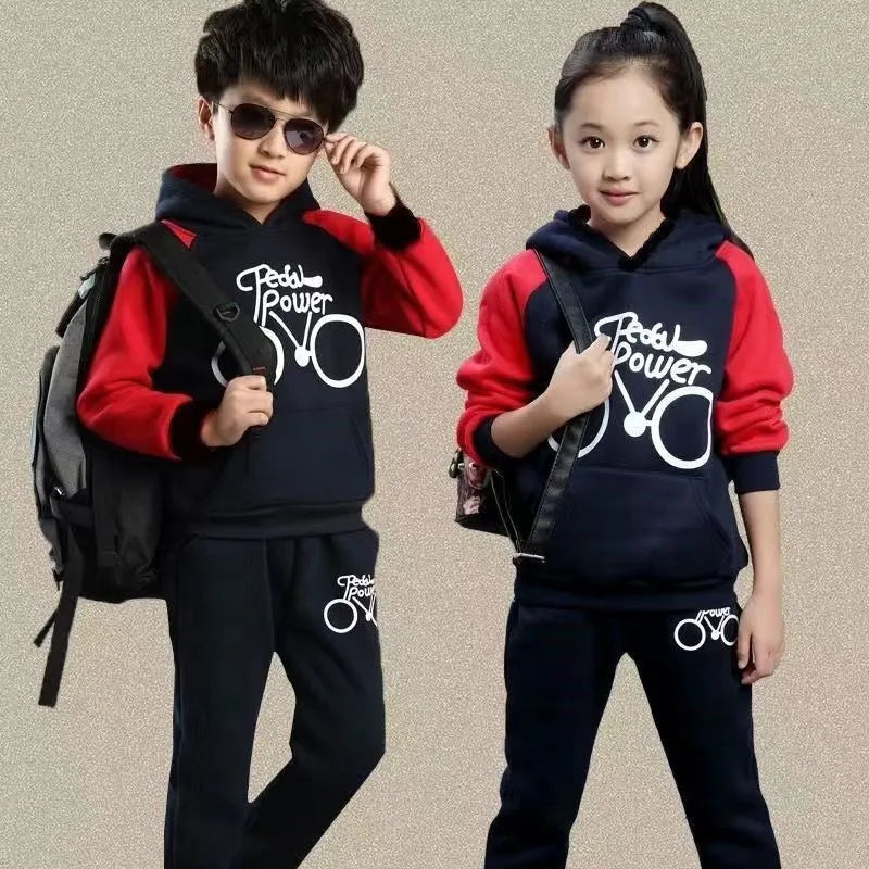 Older child wearing a black two-piece sports suit with long sleeves and print detail.