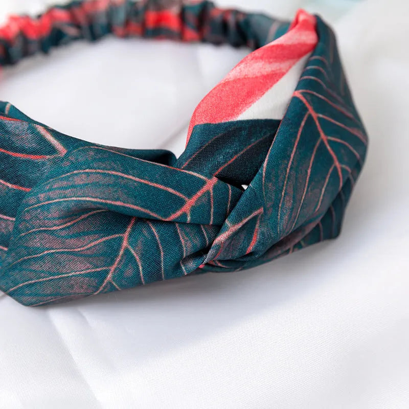 Red cloth headband with banana leaf pattern for women, showing elastic band construction