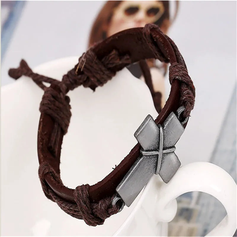 Brown leather cross bracelet with alloy accent, adjustable drawstring, vintage style on wrist
