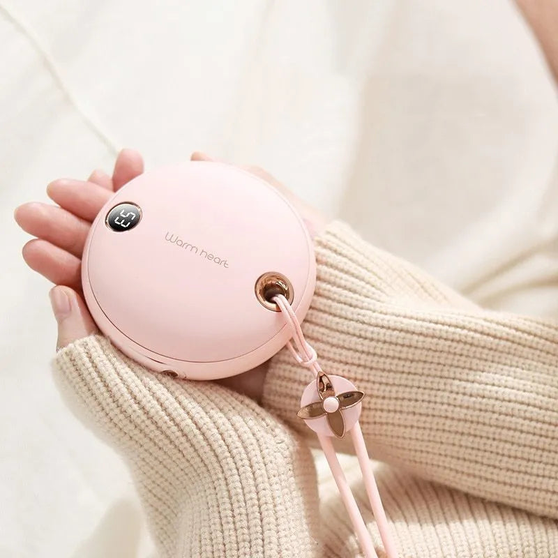Green portable hand warmer power bank with digital display showing 5000mAh capacity