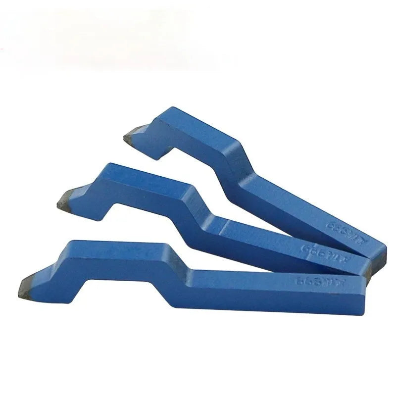 Gold-coloured curved character steel stamping tool for jewellery making on a workbench.