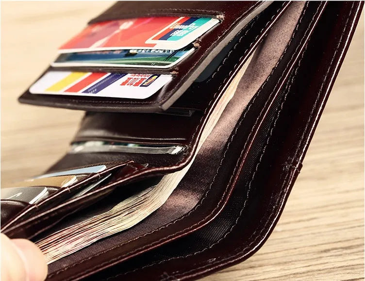 Men's black leather wallet open to show internal card slots, coin pocket, and banknote compartment.