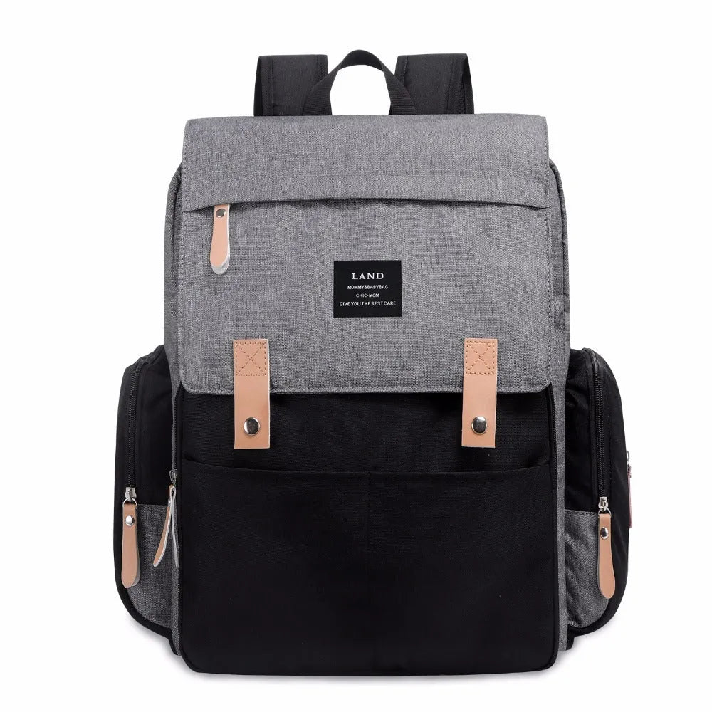 LAND Mommy large grey Oxford cloth diaper backpack with changing mat, shown on a table