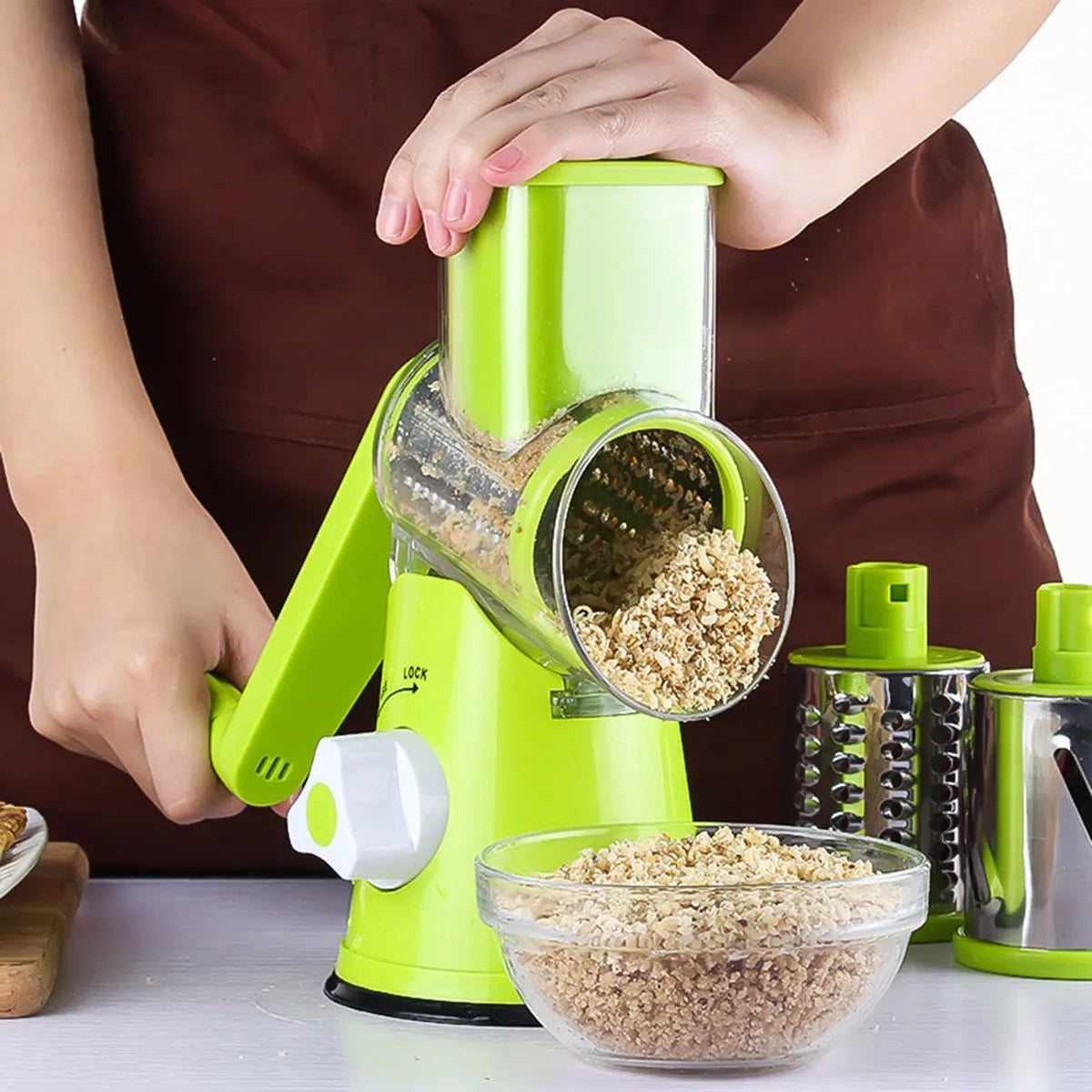 Round vegetable mandoline slicer with stainless steel blades and suction base in green colour