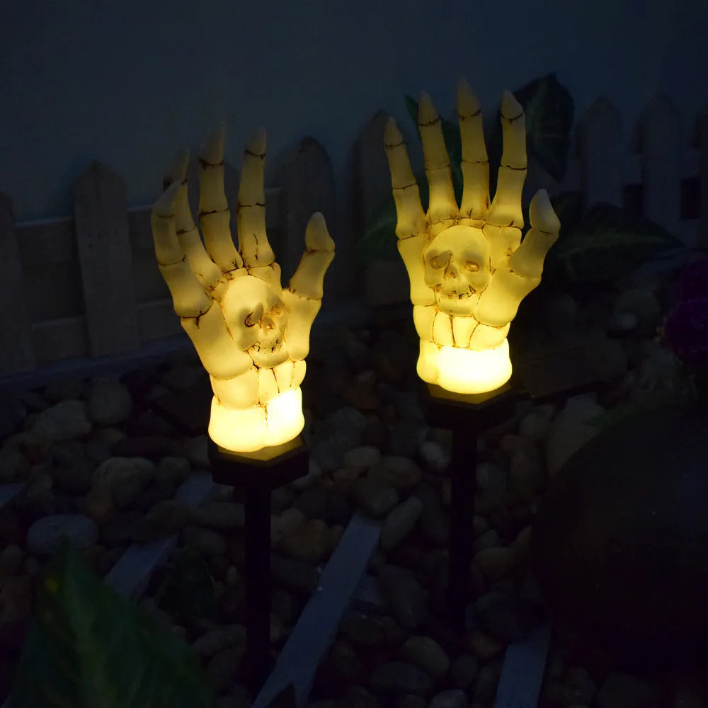 Halloween ghost hand solar light in garden setting with warm white glow, plastic IP55 waterproof construction
