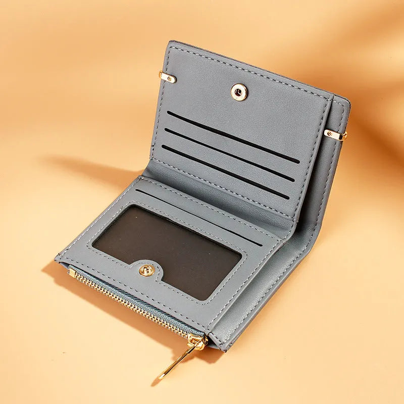 Black ladies bi-fold wallet with a gold zipper, open to show multiple card slots and a coin compartment.