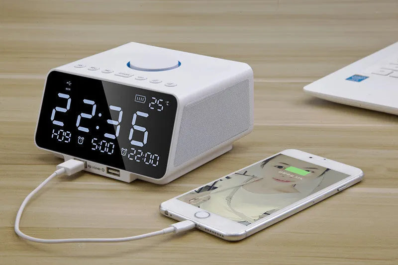 Black and white wireless alarm clock Bluetooth speaker with control buttons on top.