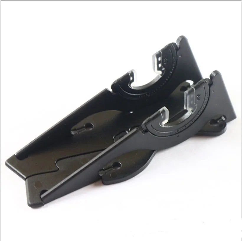 A black plastic card-type mobile phone stand on a desk.