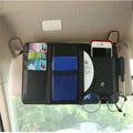 Beige car sun visor storage bag with seven open pockets, zip pocket, sunglasses clip, and pen holder on vehicle visor