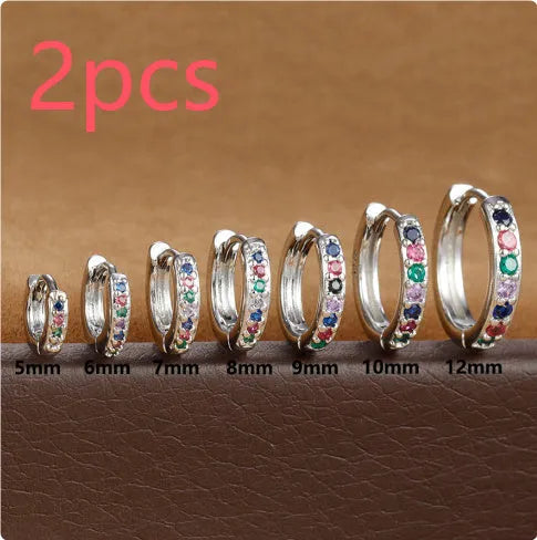 Set of three pairs of perforated circle stud earrings in gold, rose gold, and silver colours on a plain background.