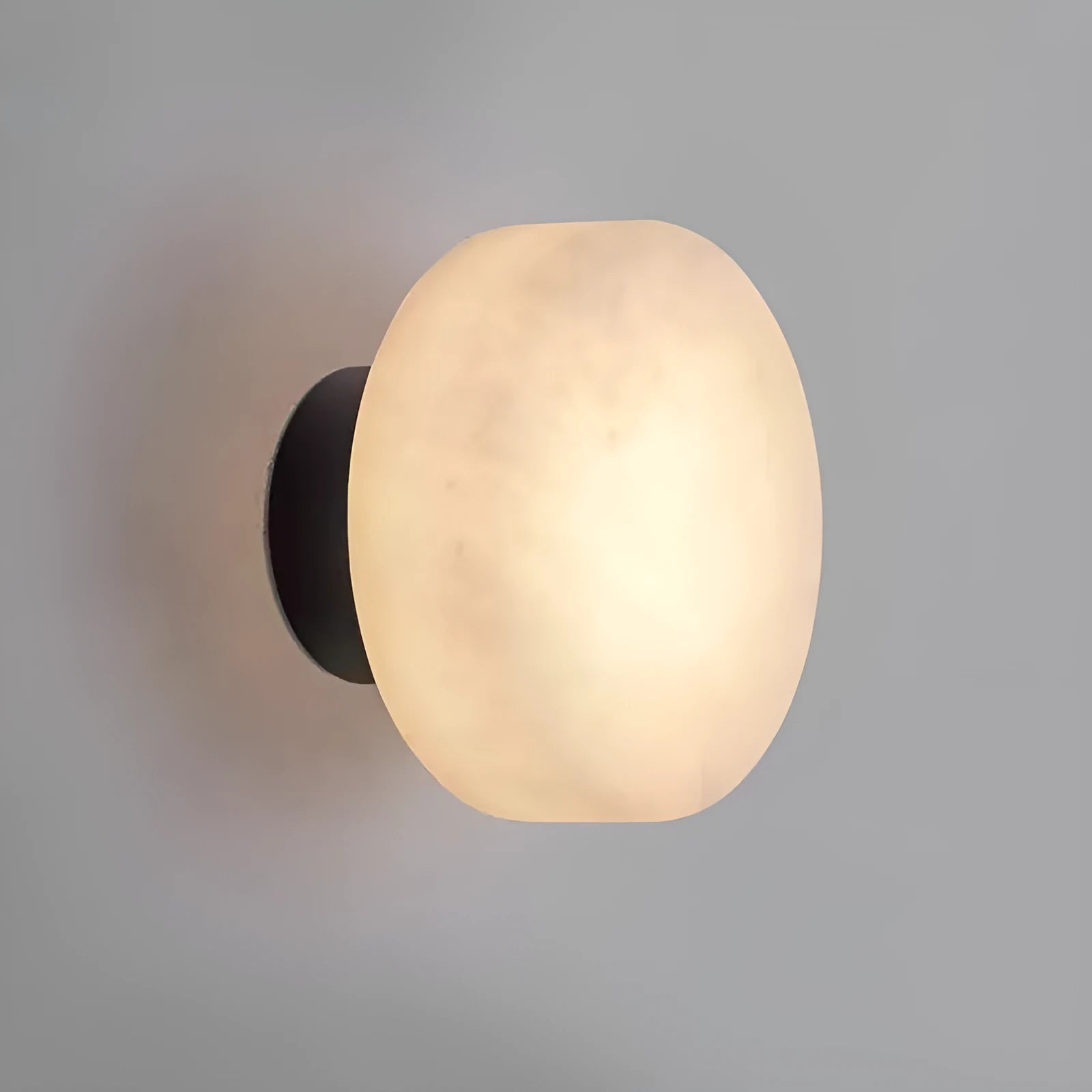Spanish natural marble round wall lamp with warm light, 130mm diameter, black finish on a bedroom wall