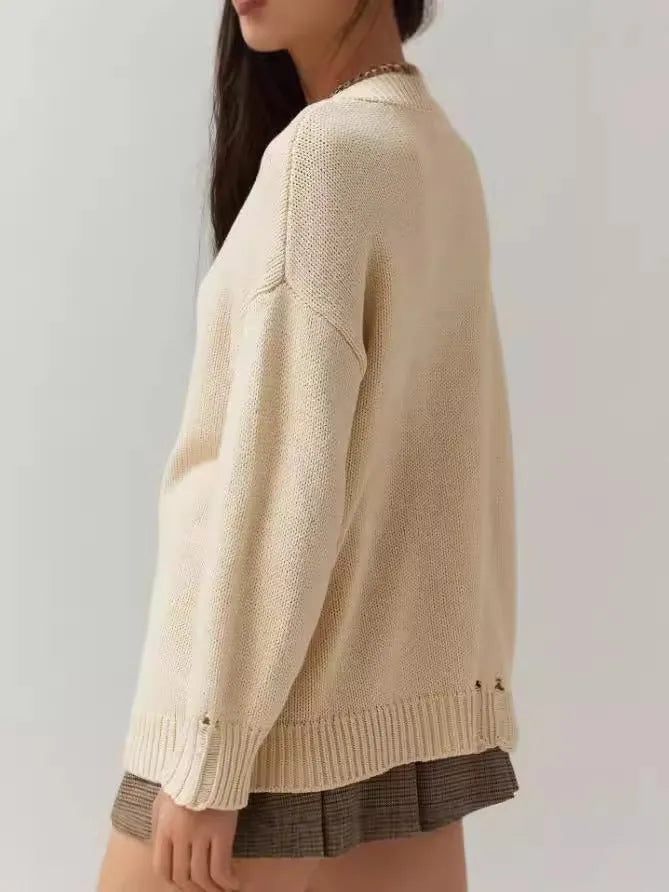 Women's beige acrylic jacquard loose-fitting pullover sweater with round neck and long sleeves.