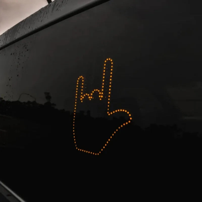 Black LED gesture car light with amber illumination showing hand gesture, remote control, and 3M Velcro mounting