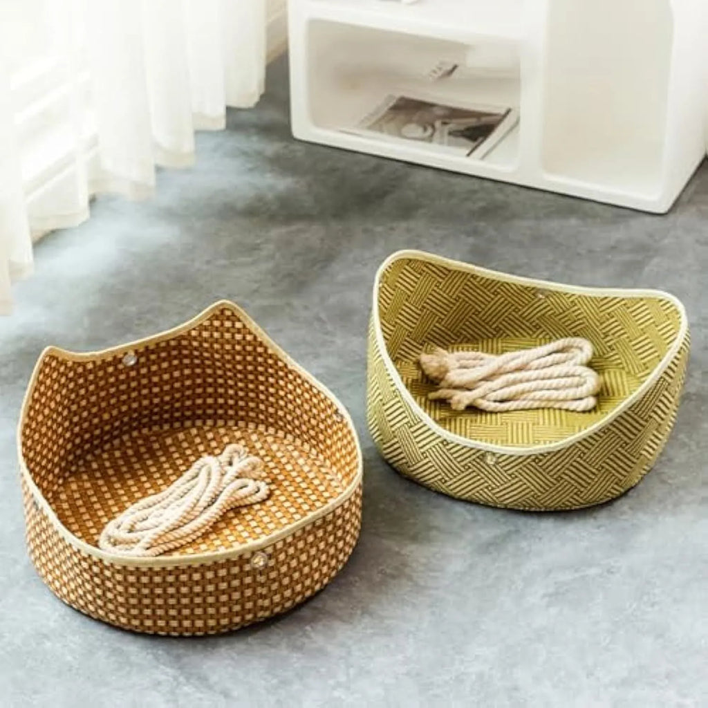 Green rattan cat hammock with metal hooks hanging on a white fence, a cat lounging inside.
