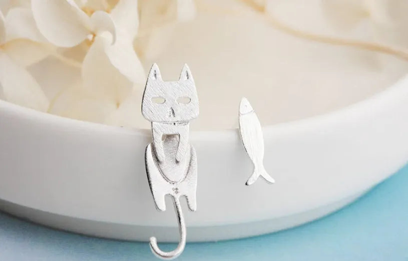 S925 sterling silver stud earrings with asymmetrical cat and fish design on white background
