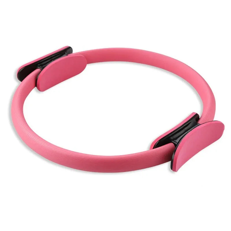 Pink pilates ring with ergonomic design on white background for yoga and home workout resistance training
